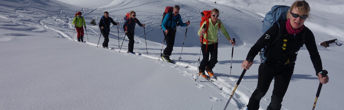 Ein Gruppe von Einsteigern hintereinander im Aufstieg mit den Skis auf der Schnupperskitour