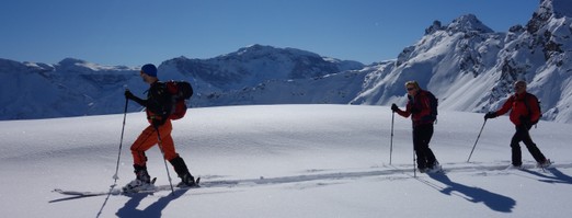 Drei Skitourenläufer vor der Kulisse der Glarner Alpen