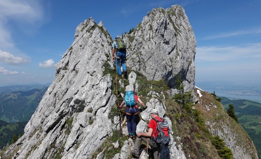 Eine Seilschaft mit drei Personen klettert über den Felsgrat